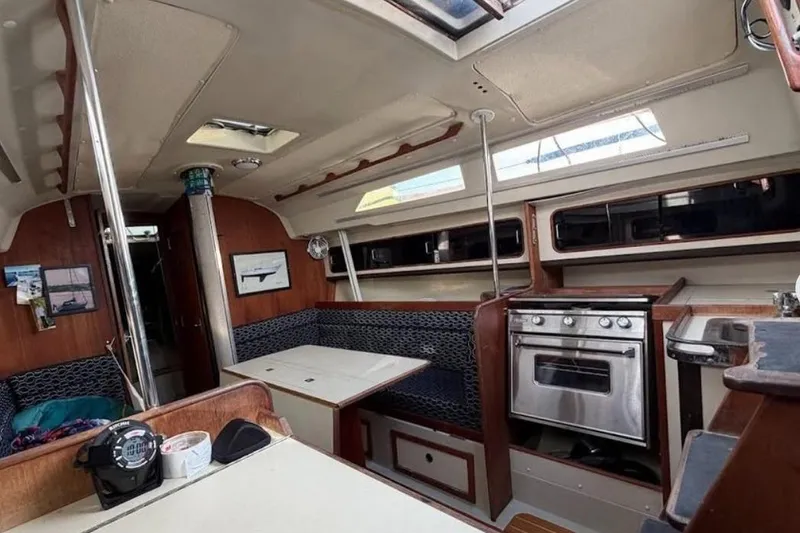 Slide: The Image of Interior of a 1982 C&C 34 sailboat featuring a cozy dining area and compact kitchen. - 19