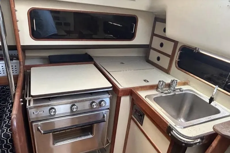 Slide: The Image of 1982 C&C 34 yacht kitchen with stove, sink, and storage cabinets. - 20
