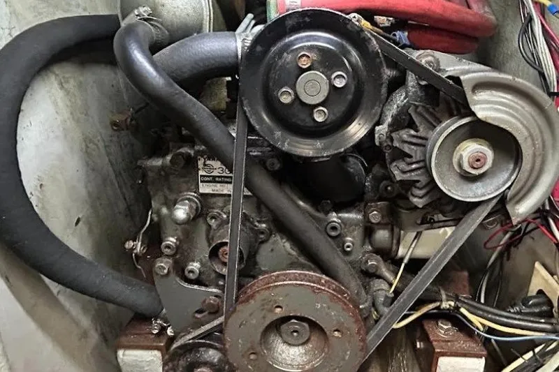 Slide: The Image of 1982 C&C 34 engine with belts and hoses in a compact setup. - 25