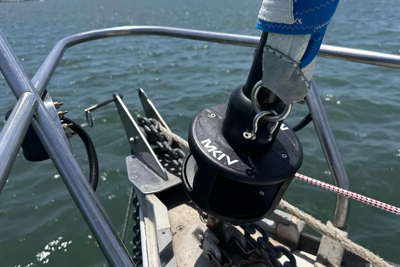 Slide: The Image of Bow of 1982 C&C 34 sailboat with anchor chain and furling system on water. - 4