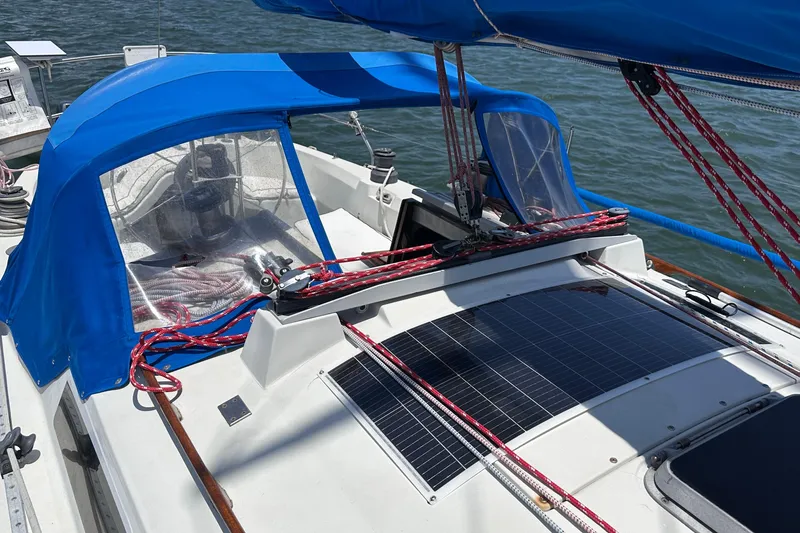 Slide: The Image of 1982 C&C 34 sailboat cockpit with blue canopy and solar panels on deck. - 6