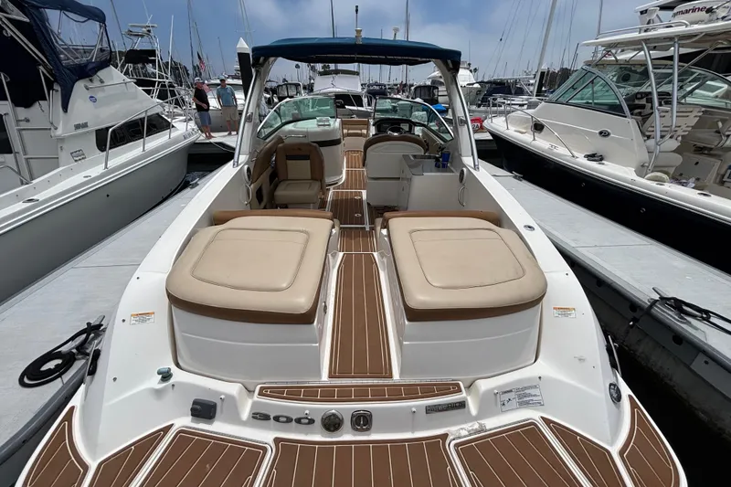 Slide: The Image of 2015 Sea Ray 300 SLX boat docked at marina, featuring spacious seating and sleek design. - 2