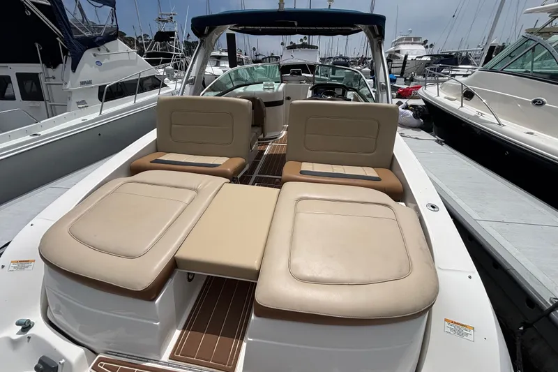 Slide: The Image of 2015 Sea Ray 300 SLX boat with beige seating, docked at a marina. - 3