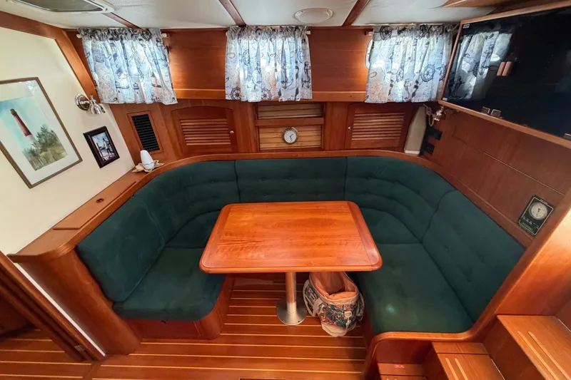 Slide: The Image of Interior of 2000 Sabreline 36 Express yacht with wooden table and green seating. - 16