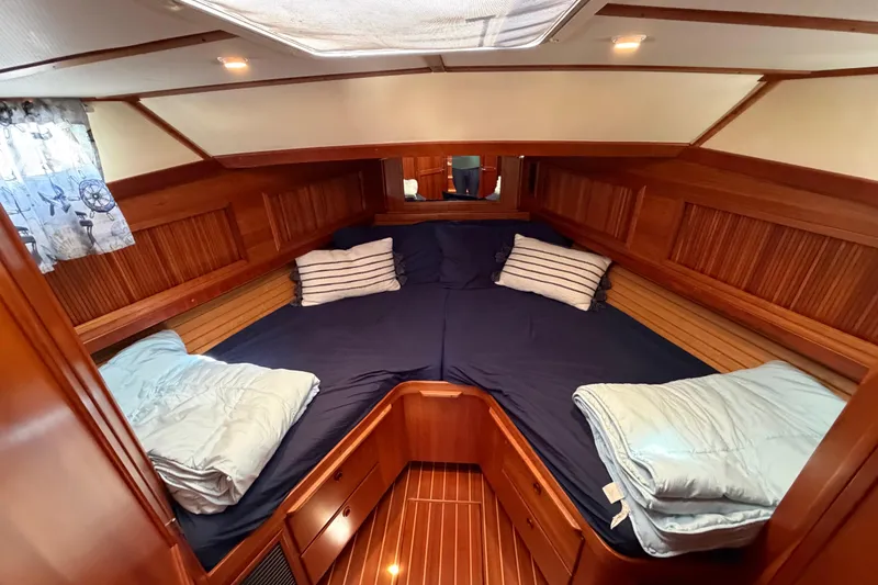 Slide: The Image of Cozy cabin interior of 2000 Sabreline 36 Express with wood paneling and blue bedding. - 19