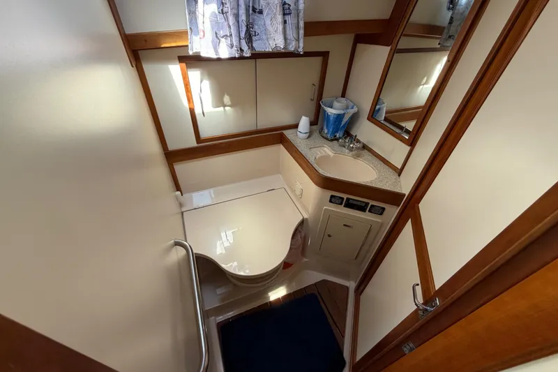 Slide: The Image of Bathroom interior of 2000 Sabreline 36 Express yacht, featuring sink and toilet. - 27
