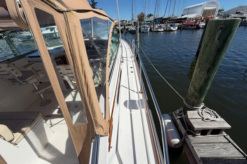 Slide: The Image of 2000 Sabreline 36 Express yacht docked at marina, featuring tan canopy and sleek design. - 28
