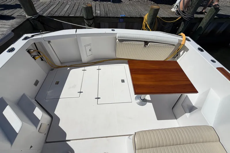 Slide: The Image of 2000 Sabreline 36 Express boat deck with wooden table and cushioned seating. - 42