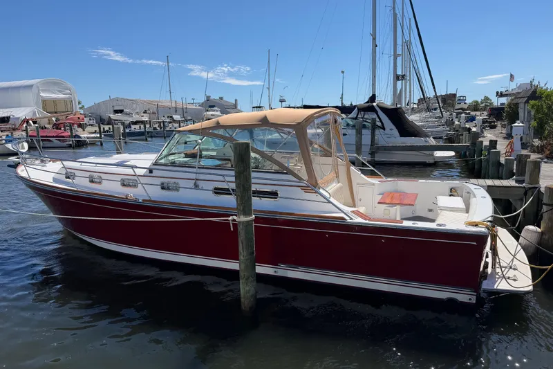 Slide: The Image of 2000 Sabreline 36 Express boat docked at a marina under clear blue skies. - 48