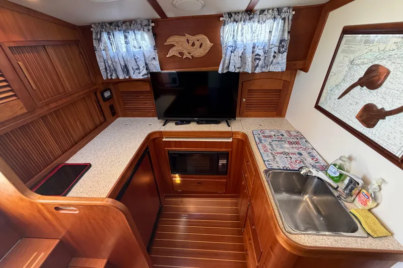 Slide: The Image of Interior of 2000 Sabreline 36 Express yacht with kitchenette, TV, and wooden cabinetry. - 18