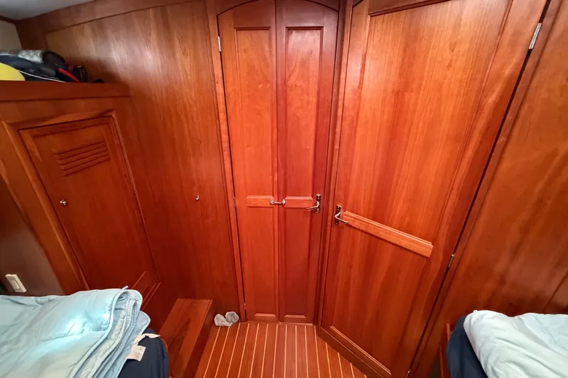 Slide: The Image of Wood-paneled cabin interior of 2000 Sabreline 36 Express yacht, featuring cozy bedding and storage. - 23