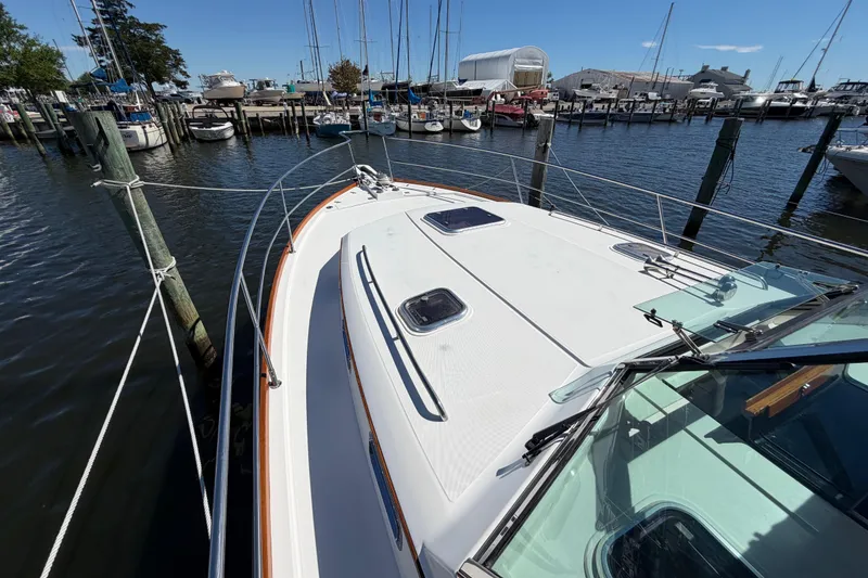 Slide: The Image of 2000 Sabreline 36 Express yacht docked at a marina with sailboats in the background. - 30