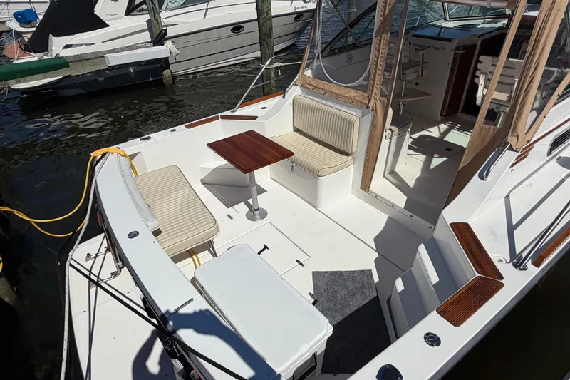 Slide: The Image of 2000 Sabreline 36 Express boat interior with seating and table in a marina. - 4