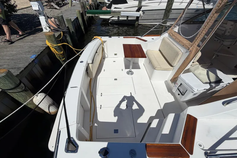 Slide: The Image of 2000 Sabreline 36 Express boat interior with seating, table, and dockside view. - 43