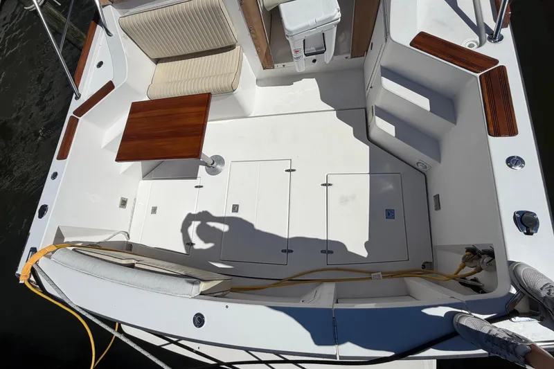 Slide: The Image of 2000 Sabreline 36 Express boat deck with seating, table, and storage compartments. - 44