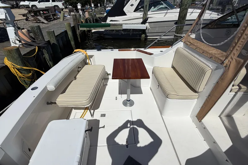 Slide: The Image of 2000 Sabreline 36 Express boat interior with seating and table at dock. - 6