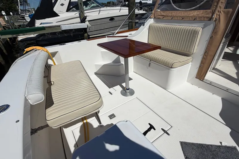 Slide: The Image of 2000 Sabreline 36 Express boat interior with cushioned seating and wooden table. - 7