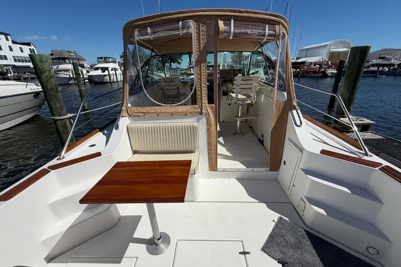 Slide: The Image of 2000 Sabreline 36 Express yacht docked, featuring a spacious deck and seating area. - 8