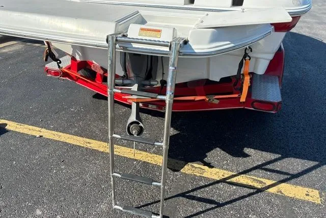 Slide: The Image of Rear view of a 2003 Crownline 208 LX boat with a ladder and trailer. - 13