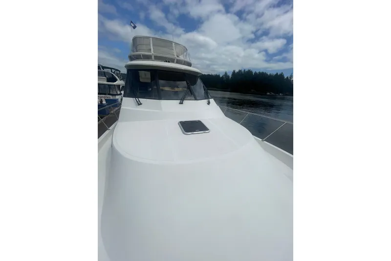 Slide: The Image of 2002 Canoe Cove 50 Pilothouse Luxury Yacht on calm water under cloudy sky. - 11
