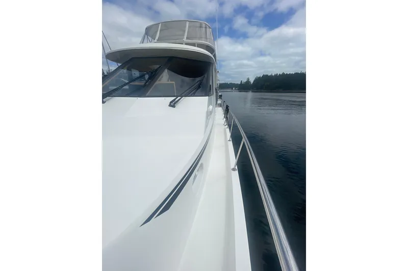 Slide: The Image of 2002 Canoe Cove 50 Pilothouse Luxury Yacht on calm water under cloudy sky. - 12