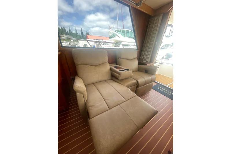 Slide: The Image of Luxurious seating inside a 2002 Canoe Cove 50 Pilothouse Yacht, featuring plush recliners. - 16