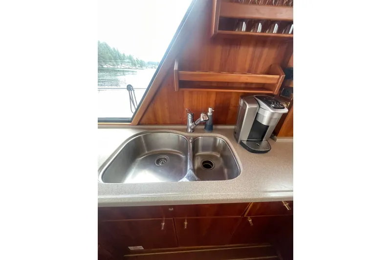 Slide: The Image of Luxury yacht kitchen with dual sink, coffee maker, and wooden cabinetry, Canoe Cove 50 Pilothouse, 2002. - 21