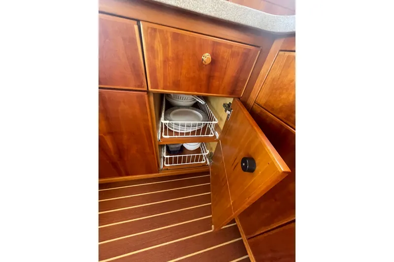 Slide: The Image of Wooden cabinetry with pull-out wire racks in a 2002 Canoe Cove 50 Pilothouse Luxury Yacht. - 22