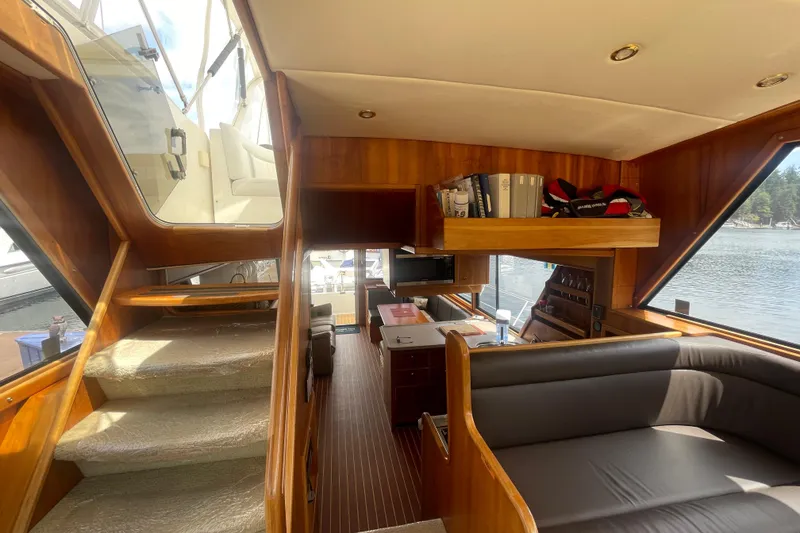 Slide: The Image of Interior of 2002 Canoe Cove 50 Pilothouse Luxury Yacht with wood accents and seating area. - 32