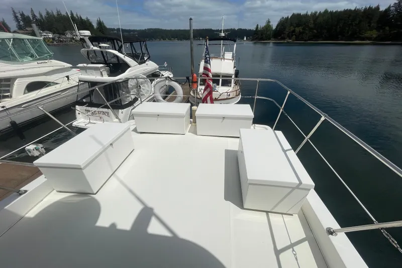 Slide: The Image of 2002 Canoe Cove 50 Pilothouse Luxury Yacht docked, featuring spacious deck and scenic waterfront view. - 34