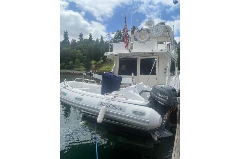 Slide: The Image of Canoe Cove 50 Pilothouse Luxury Yacht 2002 docked with inflatable boat and Yamaha motor. - 4