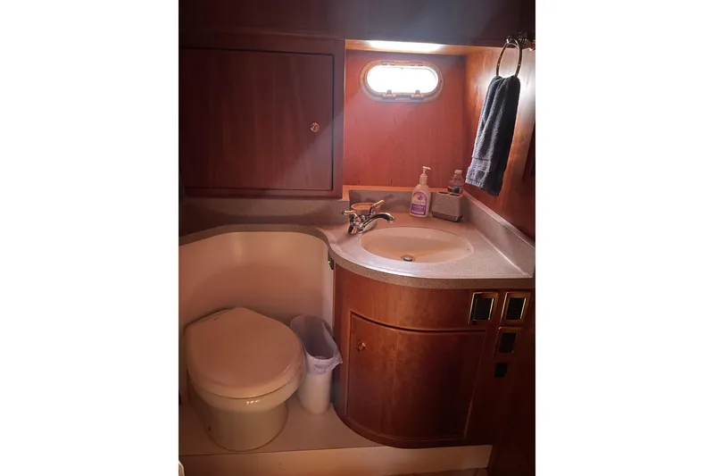 Slide: The Image of Luxurious bathroom in 2002 Canoe Cove 50 Pilothouse Yacht with wooden cabinetry. - 50