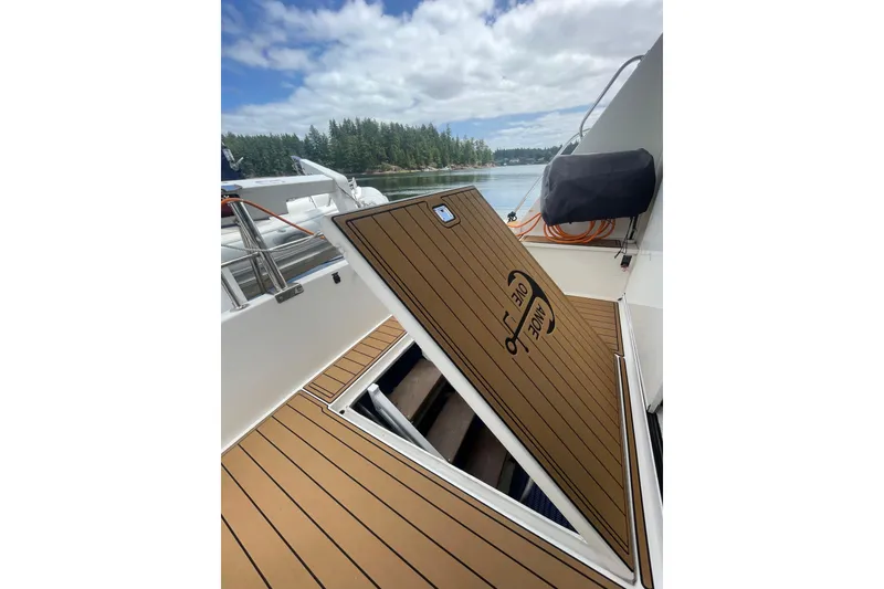 Slide: The Image of 2002 Canoe Cove 50 Pilothouse Luxury Yacht deck with open hatch, scenic water view. - 54