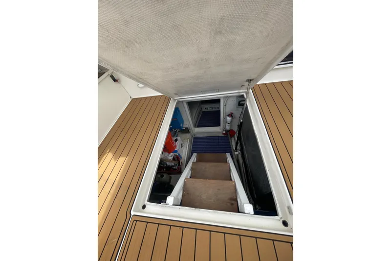 Slide: The Image of Open hatch on 2002 Canoe Cove 50 Pilothouse Yacht, revealing interior stairs and equipment. - 55