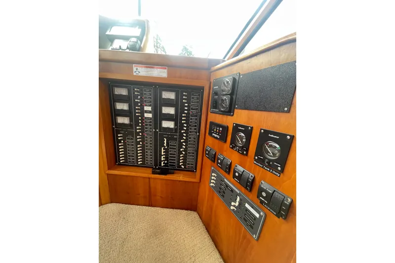 Slide: The Image of Control panel of 2002 Canoe Cove 50 Pilothouse Luxury Yacht, featuring various gauges and switches. - 65