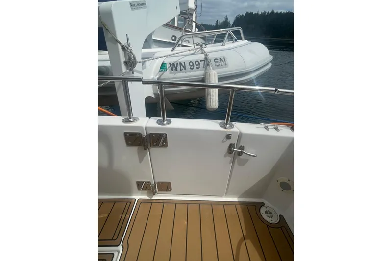 Slide: The Image of Canoe Cove 50 Pilothouse Luxury Yacht, 2002, with teak deck and docked tender boat. - 7