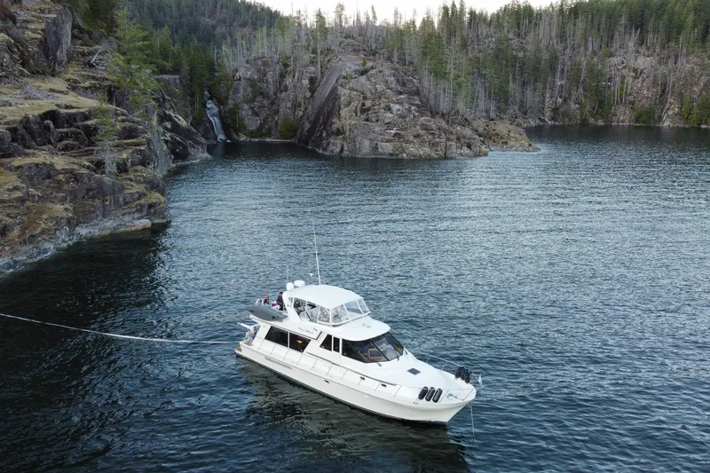 Slide: The Image of Canoe Cove 50 Pilothouse Luxury Yacht anchored in scenic rocky cove, 2002 model. - 72