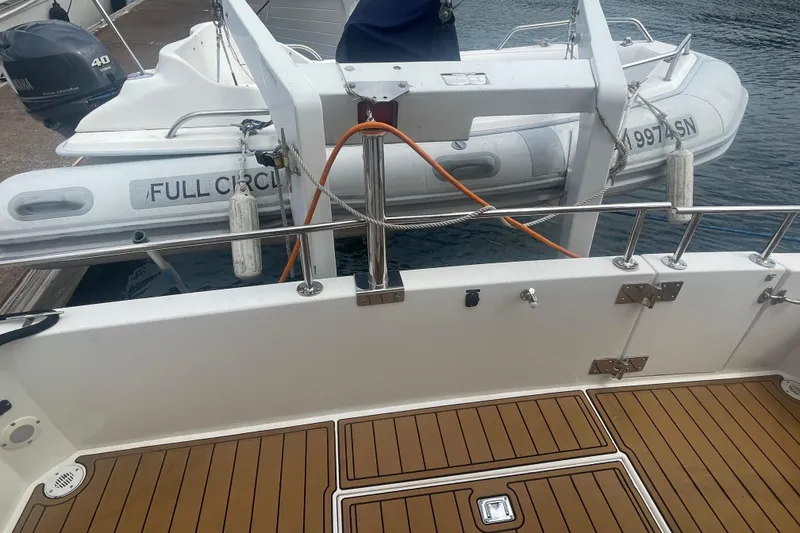 Slide: The Image of Canoe Cove 50 Pilothouse Yacht deck with dinghy, 2002 model, docked at marina. - 8