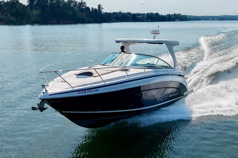 Slide: The Image of 2021 Regal 33 Express boat cruising on a serene lake. - 80