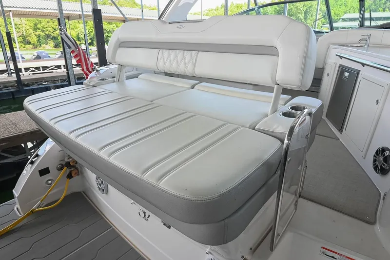 Slide: The Image of 2021 Regal 33 Express boat interior with white cushioned seating and cup holders. - 10