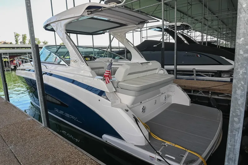 Slide: The Image of 2021 Regal 33 Express boat docked in a marina, featuring sleek design and American flag. - 3