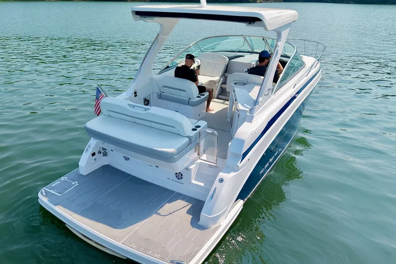 Slide: The Image of 2021 Regal 33 Express boat cruising on a serene lake with passengers onboard. - 79
