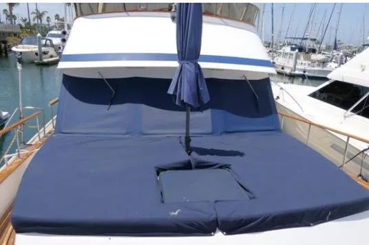 Slide: The Image of 1983 Chung Hwa Sedan Trawler with blue sun deck cushions and umbrella, docked at marina. - 1