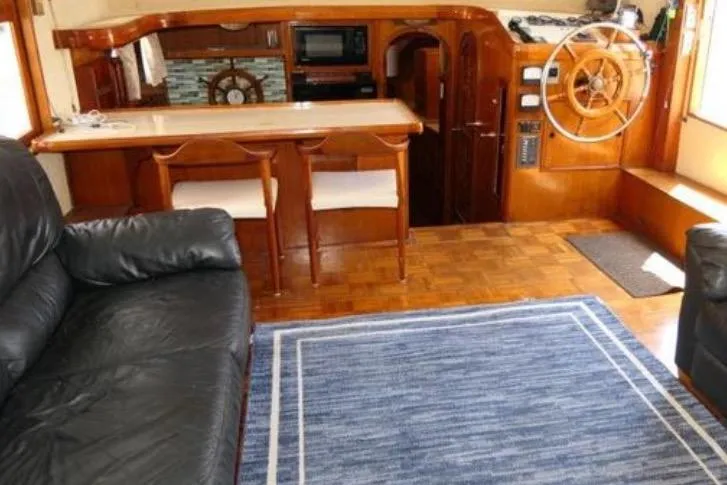 Slide: The Image of Interior of 1983 Chung Hwa Sedan Trawler with wooden helm, seating, and blue rug. - 11