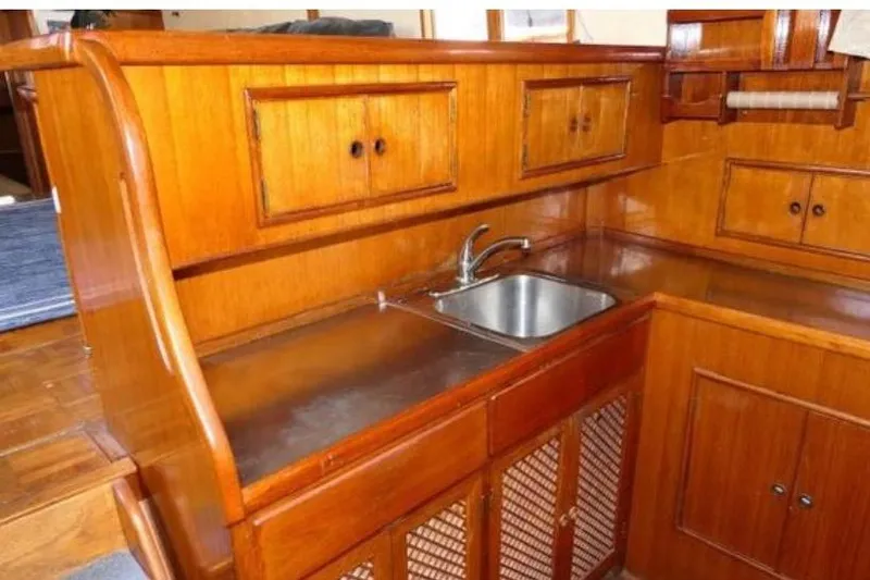 Slide: The Image of 1983 Chung Hwa Sedan Trawler interior with wooden cabinetry and stainless steel sink. - 13