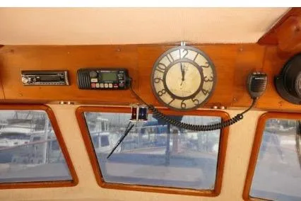 Slide: The Image of 1983 Chung Hwa Sedan Trawler interior with clock, radio, and windows overlooking marina. - 15