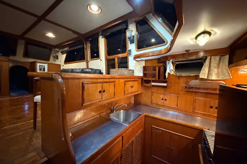 Slide: The Image of 1983 CHB Sedan Trawler interior with wooden cabinetry and stainless steel sink. - 17