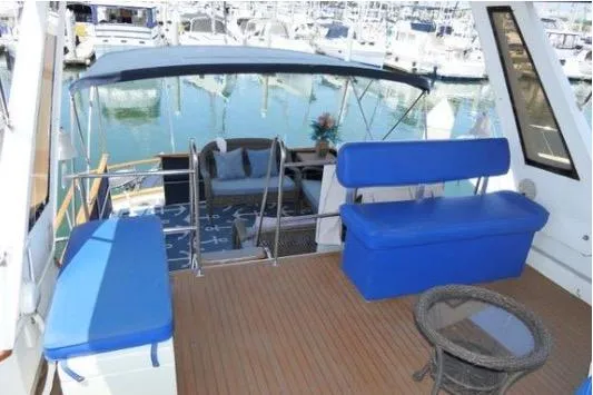 Slide: The Image of 1983 Chung Hwa Sedan Trawler deck with blue seating, overlooking marina. - 4