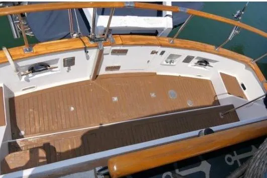 Slide: The Image of 1983 Chung Hwa Sedan Trawler deck with wooden flooring and railing, docked at marina. - 7