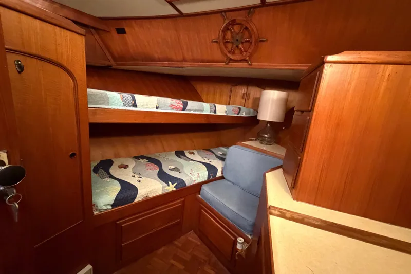 Slide: The Image of Cozy 1983 CHB Sedan Trawler cabin with wooden interior and bunk beds. - 16
